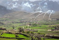 An AH-64 Apache helicopter shoots flares over a valley to support members of the 8th Commando Kandak and coalition special operations forces during a firefight near Nawa Garay village, Kajran district in April 2012.