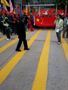 People protesting in Hong Kong with two persons holding a PRC flag.