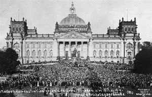 Thousands of people gather in front of a building.