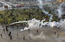 Egyptian security forces largely eschewed deadly force, relying instead on batons and water cannons to respond to protesters. Above, police fire tear gas into a gathering of demonstrators in central Cairo. ومع حلول الظلام، بدأت الشرطة في تفريق المتظاهرين ياستخدام الرصاص المطاطي والغاز المسيل للدموع.
