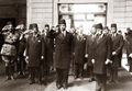 خروج الملك فاروق الأول من محطة مصر مع الوزراء وهو يؤدي التحية العسكرية. وعلى يمينه علي ماهر باشا رئيس الوزراء. الصورة التقطت بين 28 أبريل (توليه العرش) - 9 مايو 1936 (مغادرة علي ماهر الوزارة).