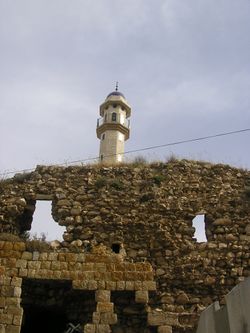 آثار قلعة ضاهر العمر في دير حنا ويظهر في الخلفية مسجد القرية
