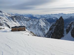 mountain refuge overlooking snow-covered Swiss mountains