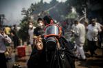 واحدة من أنصار مرسي ترتي قناعة واقي من القنابل المسيلة للدموع بعد إطلاقها من قوات الأمن أثناء فض اعتصامات رابعة العدوية.