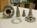 Low pressure mix head components, including mix chambers, conical mixers, and mounting plates.