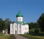 A white orthodox church with a green roof