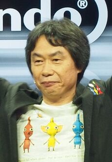 Shigeru Miyamoto, a middle-aged Japanese man wearing a herringbone blazer and white shirt.