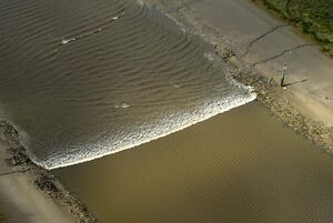 A tidal bore wave moves along the River Ribble between the entrances to the Rivers Douglas and Preston.