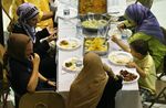 A member of Fairfax County Fire and Rescue, lower left, participates in an Iftar, the evening meal when Muslim break their fast during Ramadan, August 17, 2010 at Dar Al-Hijrah Islamic Center in Falls Church, Virginia. The Islamic center invited frontline responders for Ramadan dinner to show appreciation and foster increased understanding. (Alex Wong/Getty Images)