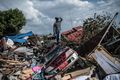 A man stands atop a car and other debris on October 2 in Palu.jpg