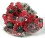 Rhodochrosite with fluorite, tetrahedrite and quartz; the tetrahedrite occurs as sharp, metallic crystals