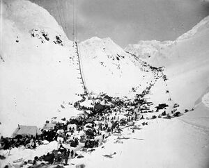 Prospectors with supplies at The Chilkoot Pass. In front: The Scales. Left: Golden Steps, right: Pederson Pass. March–April 1898