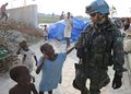 جندي مشارك في مهمة حفظ السلام الأممية يمشي مع أطفال هايتيين أثناء دورية في سيتي سوليل، قطاع في پورت-أو-پرنس، هايتي.