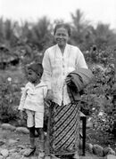 Portrait of a woman in sarong and kebaya with child