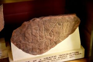 Museum exhibit of a fragmentary slab of stone with a Nabataean graffito labeled "Fragment of a Sinaitic inscription"