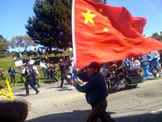A man in San Francisco holding the PRC flag during the torch relay for the 2008 Summer Olympics.