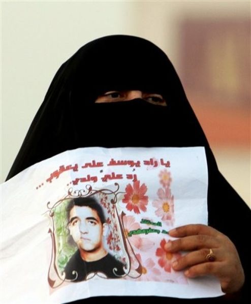 ملف:سيدة بحرينية في مظاهرة بالمعامير تحمل صورة ابنها ضمن الشيعة المعتقلين لدى الحكومة البحرينية 14 فبراير 2011.jpg