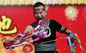 Man pulls ribbons from his mouth temple of the earth 2014.jpg