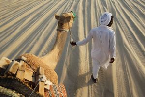 دليل يقود أحد السائحين في رحلة بالصحراء قرب مدينة أم سعيد، قطر.