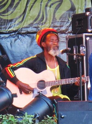 Smith seated playing acoustic guitar