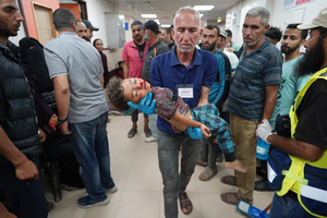 فلسطيني يحمل جثة طفل قتلته اسرائيل خلال عملية النصيرات