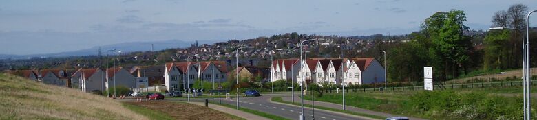 Dunfermline seen from the town's eastern expansion area. The chimney stacks at Grangemouth and Longanett can be seen in the distance