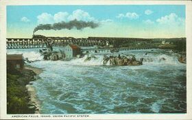 A painted postcard shows a train crossing a bridge above a wide waterfall and turbulent river.