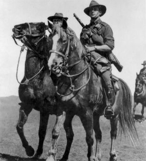 Soldiers mounted on horses with rifles slung