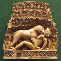 Nimrud ivory plaque, with original gold leaf and paint, depicting a lion devouring a human (British Museum)