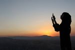 A Syrian Muslim girl stands at the top of Mount Qassioun, which overlooks Damascus city, during sunset and prays before eating her Iftar meal on August 22, 2010. (REUTERS/Khaled al-Hariri)