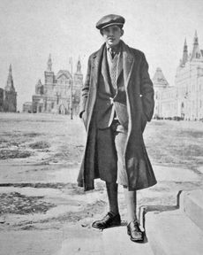 Historic photo of a handsome young man, Palle Huld, standing before classic Russian architecture