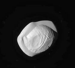 بان، قمر زحل، يبلغ متوسط نصف قطره 9 أميال تقريبًا، ويُشبه بالرافيولي أو الزلابية.