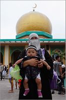 مسلمة تحمل طفلتها أمام المسجد الذهبي في مانيلا، الفلبين، 20 يوليو 2012.