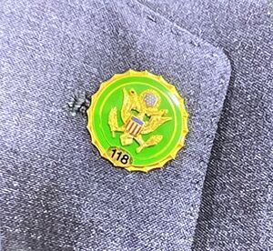 A small pin held onto an article of clothing with a Congressional seal on it