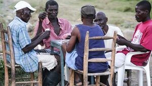 Several elderly men sitting around a table playing cards