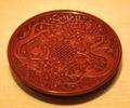 A Ming Dynasty red lacquerware dish with carved chrysanthemums and dragons