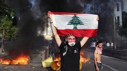 محتج يرفع علم لبنان أثناء احتجاجات بيروت 6 يونيو 2020.