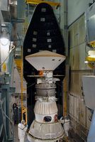 On Launch Pad 17-A at Cape Canaveral Air Force Station, the first half of the fairing is moved into place around the Phoenix Mars Lander for installation. The grey sphere is the PAM-D solid rocket that gave Phoenix the final velocity for the Martian cruise.