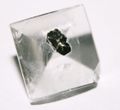 Clear gemstone with metallic inclusion.