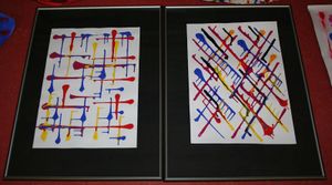 Two paintings (portrait orientation) are side by side with the only marks being thick lines that terminate with a sizeable dot of blue, yellow, or red. The left one has lines vertical/horizontal, and he right one has lines diagonally.