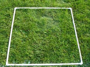 A square made of PVC pipe on grass