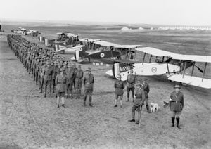 Men standing in files behind biplanes. They are wearing slouch hats, service jackets and breeches.