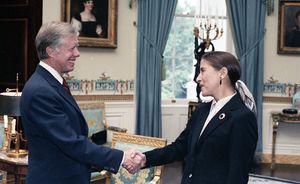 Ginsburg shaking hands with Carter as the two smile
