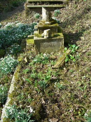 A dilapidated kerb surround style grave with a tablet and a fallen cross headstone.