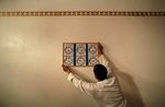 A Muslim man places a chart which marks the times to pray on a wall during the first day of Ramadan at a mosque in the southern Spanish town of Estepona, near Malaga August 11, 2010. (REUTERS/Jon Nazca)