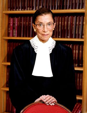 Ginsburg standing in front of a bookshelf